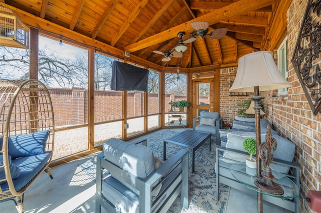 sunroom with lofted ceiling with beams, wooden ceiling, and ceiling fan