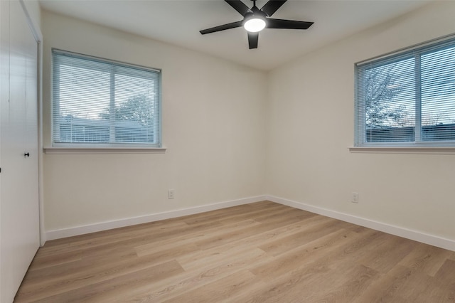 empty room featuring baseboards, light wood-type flooring, a ceiling fan, and a healthy amount of sunlight