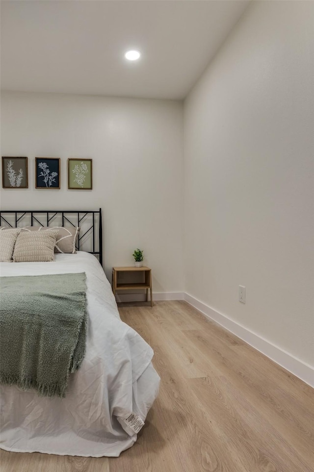 bedroom with recessed lighting, light wood-style flooring, and baseboards