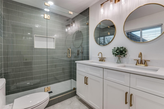 bathroom with a stall shower, a sink, and toilet