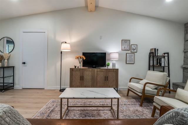 living area featuring light wood-type flooring, vaulted ceiling with beams, and baseboards