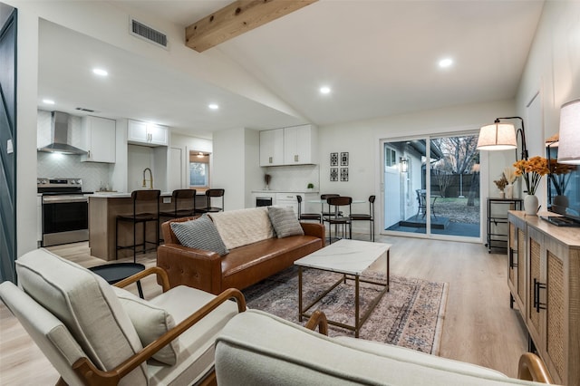 living area with light wood-type flooring, lofted ceiling with beams, visible vents, and recessed lighting