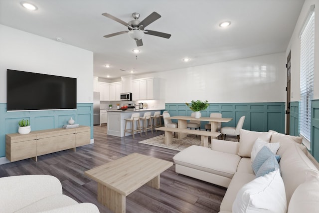 living area featuring recessed lighting, wainscoting, a ceiling fan, and dark wood-style flooring