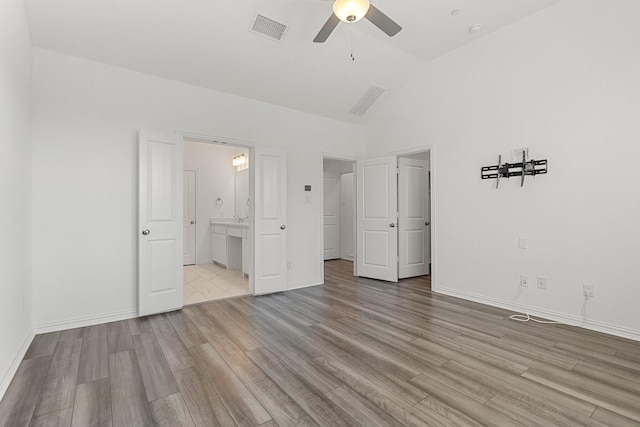 unfurnished bedroom featuring light wood finished floors, visible vents, ensuite bath, and baseboards