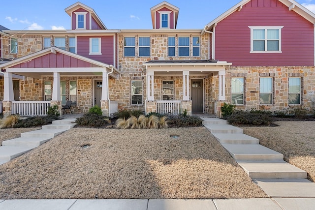 townhome / multi-family property with board and batten siding, a porch, and stone siding