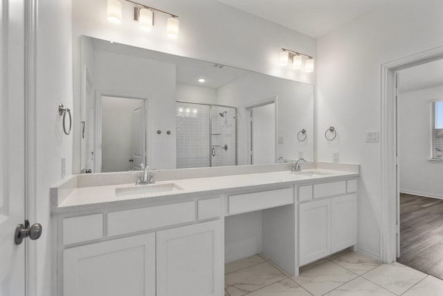 full bathroom featuring double vanity, a shower stall, and a sink