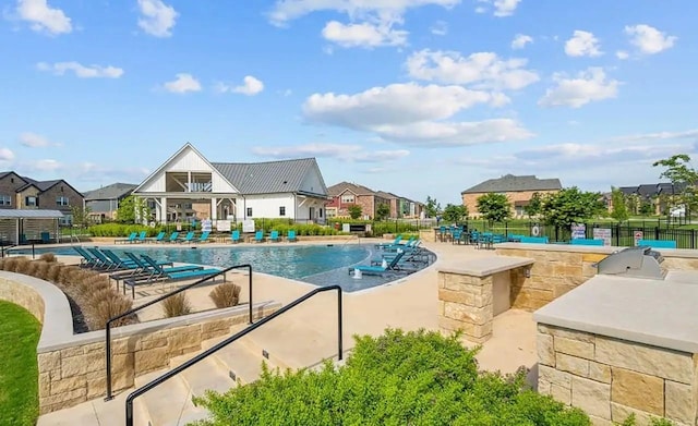 community pool with a patio area and fence