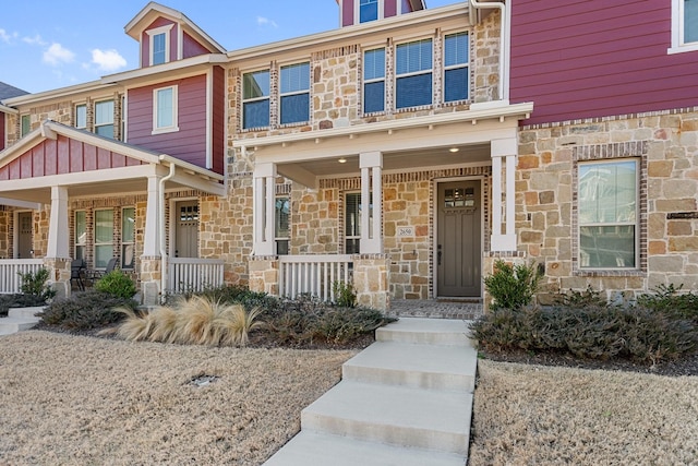 view of front of home with stone siding and a porch