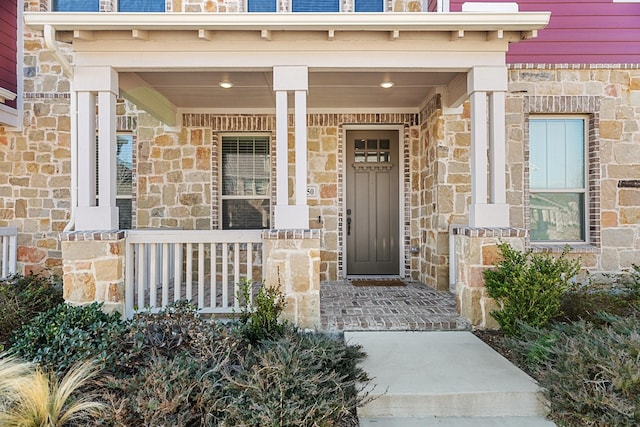 entrance to property with stone siding and covered porch