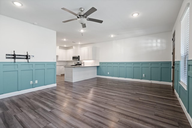 unfurnished living room featuring recessed lighting, dark wood-type flooring, a ceiling fan, and a decorative wall