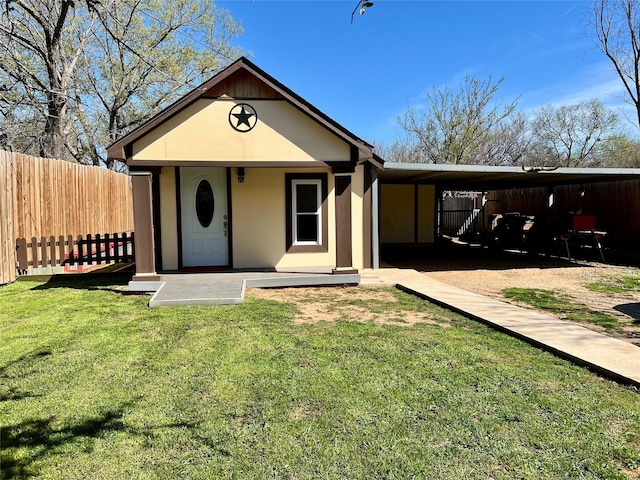 view of front of home featuring a front lawn, fence, and stucco siding