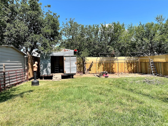 view of yard featuring an outbuilding, a shed, and a fenced backyard