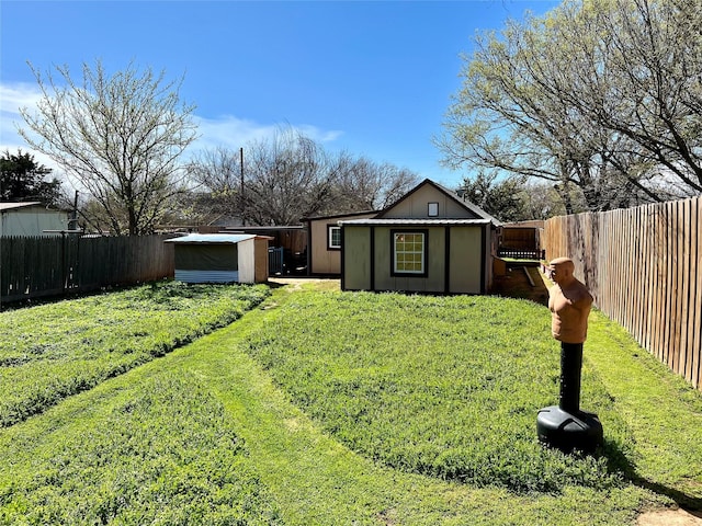 view of yard with a fenced backyard, a shed, and an outdoor structure