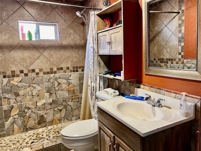 bathroom with vanity, a tile shower, and toilet