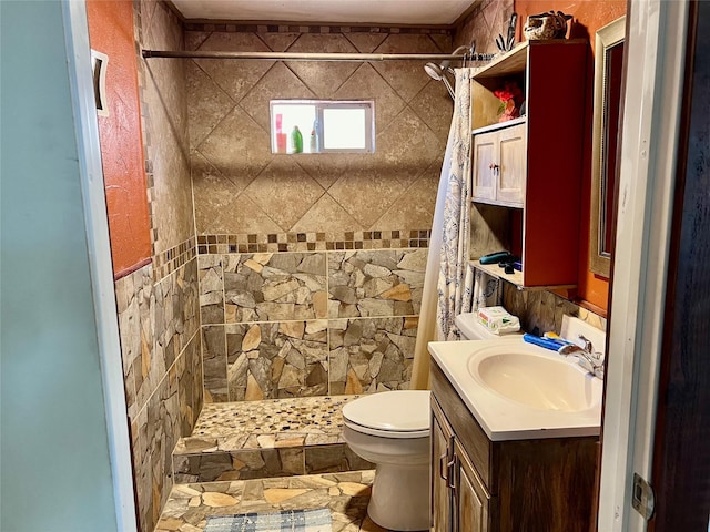 bathroom featuring toilet, a shower stall, and vanity