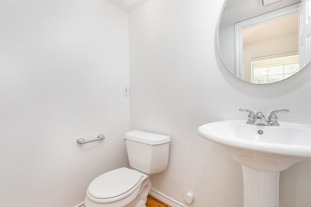 bathroom with baseboards, a sink, and toilet