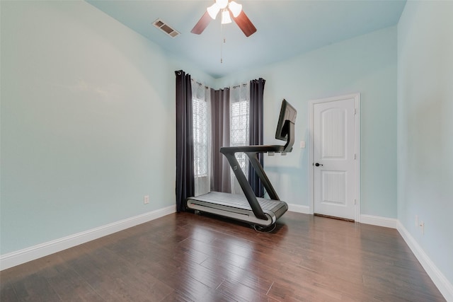 exercise room with a ceiling fan, baseboards, visible vents, and wood finished floors