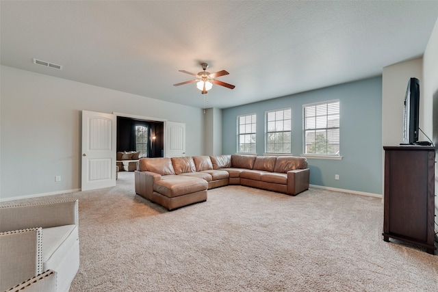 living room with a ceiling fan, carpet flooring, visible vents, and baseboards