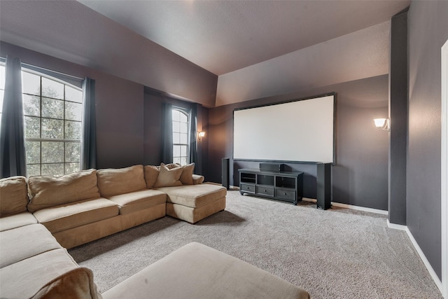 home theater featuring vaulted ceiling, carpet, and baseboards