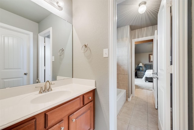 bathroom with tile patterned flooring, a textured wall, and vanity