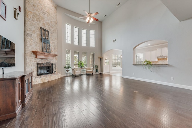 living area with dark wood-type flooring, a fireplace, visible vents, and baseboards