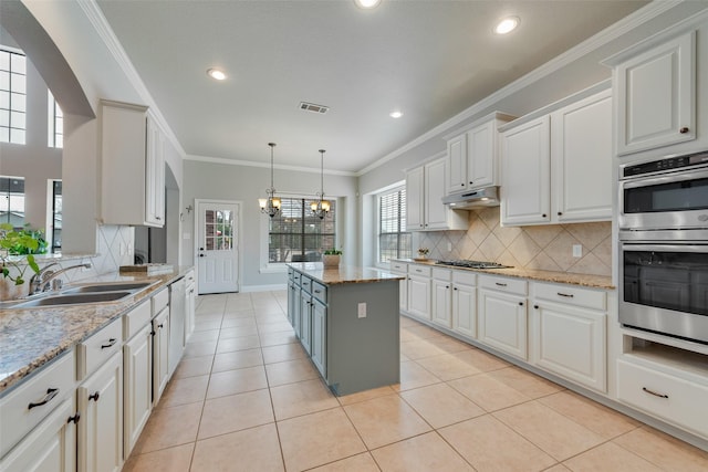 kitchen featuring a notable chandelier, visible vents, appliances with stainless steel finishes, a sink, and under cabinet range hood