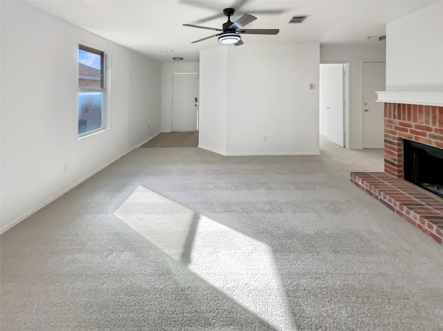 unfurnished living room featuring light carpet, visible vents, baseboards, ceiling fan, and a brick fireplace