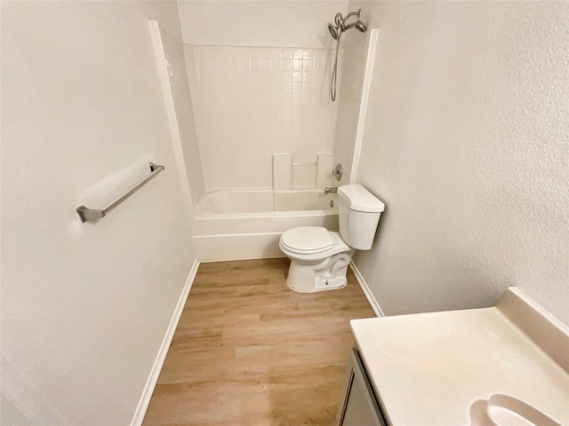 bathroom featuring baseboards, toilet, shower / tub combination, wood finished floors, and vanity