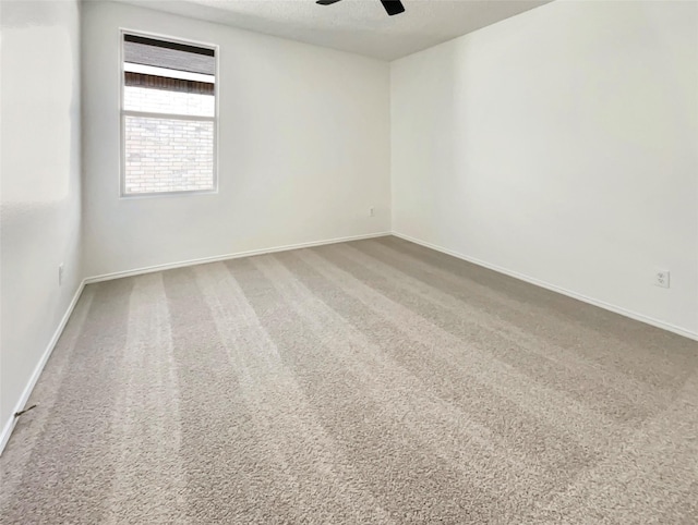 empty room featuring ceiling fan, a textured ceiling, baseboards, and carpet flooring