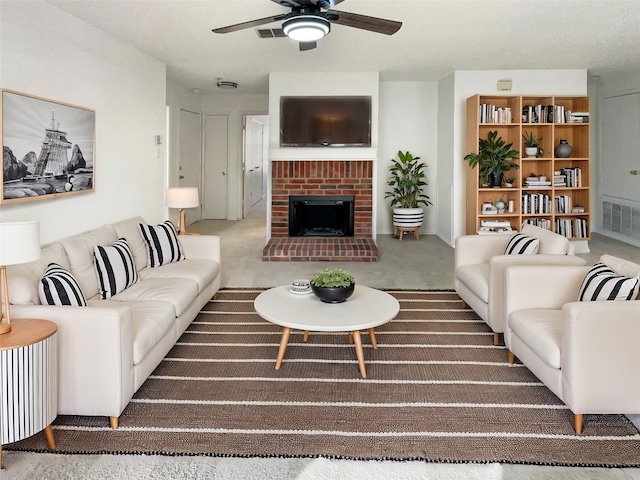 living room featuring visible vents, carpet floors, a fireplace, and a ceiling fan