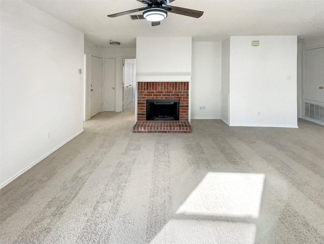 unfurnished living room featuring baseboards, visible vents, a ceiling fan, carpet, and a fireplace