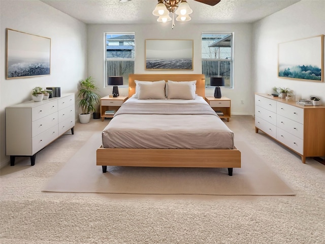 bedroom with light colored carpet, ceiling fan, a textured ceiling, and baseboards