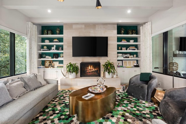 living area with recessed lighting, a tile fireplace, beam ceiling, and built in features