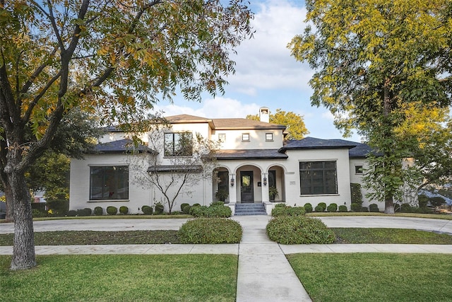 view of front of house featuring a chimney and a front lawn