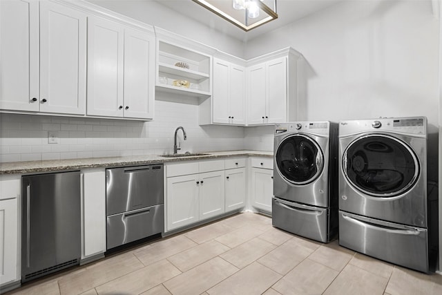 laundry room with washing machine and dryer, a sink, and cabinet space