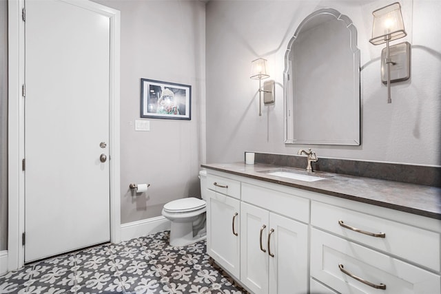 bathroom featuring vanity, toilet, and baseboards