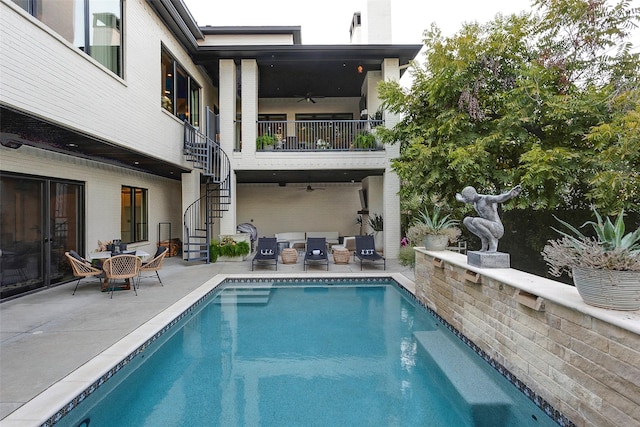 back of house with ceiling fan, an outdoor hangout area, stairway, an outdoor pool, and a patio area