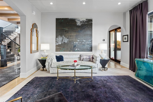 sitting room with arched walkways, wood finished floors, stairway, and recessed lighting