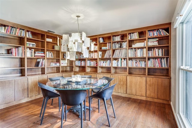 dining room with wood finished floors and a notable chandelier