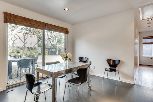 dining space featuring finished concrete flooring, baseboards, and recessed lighting