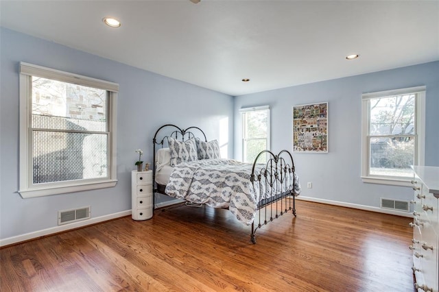 bedroom featuring multiple windows, wood finished floors, and visible vents