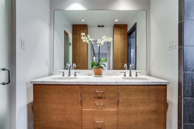 full bathroom with visible vents, a sink, and double vanity