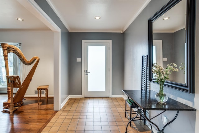 foyer entrance featuring light tile patterned floors, baseboards, visible vents, and crown molding