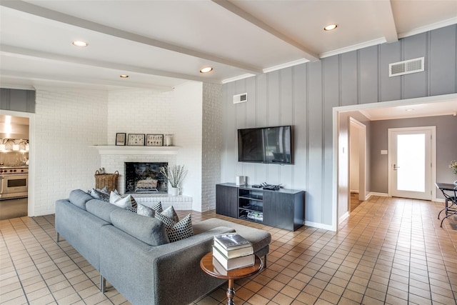 tiled living area featuring brick wall, a fireplace, visible vents, and beam ceiling