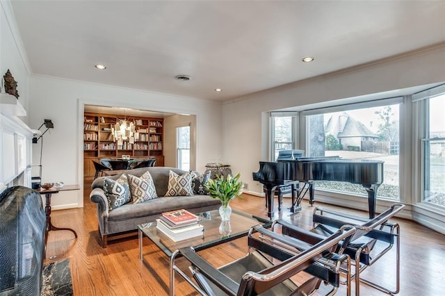 living room with recessed lighting, visible vents, baseboards, light wood-style floors, and ornamental molding