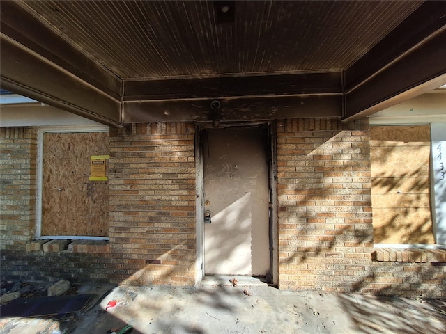 view of exterior entry featuring brick siding