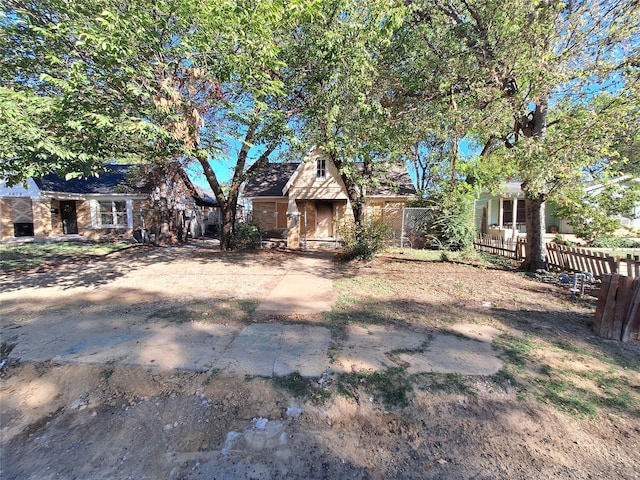 view of front facade featuring brick siding and fence