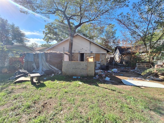 rear view of property with a yard and brick siding