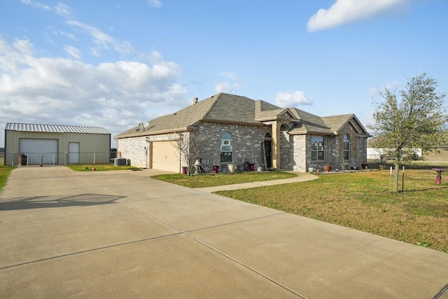 view of front of home featuring brick siding, roof with shingles, central air condition unit, a garage, and a front lawn