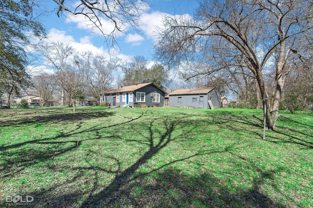 view of front of home featuring a front yard and an outbuilding